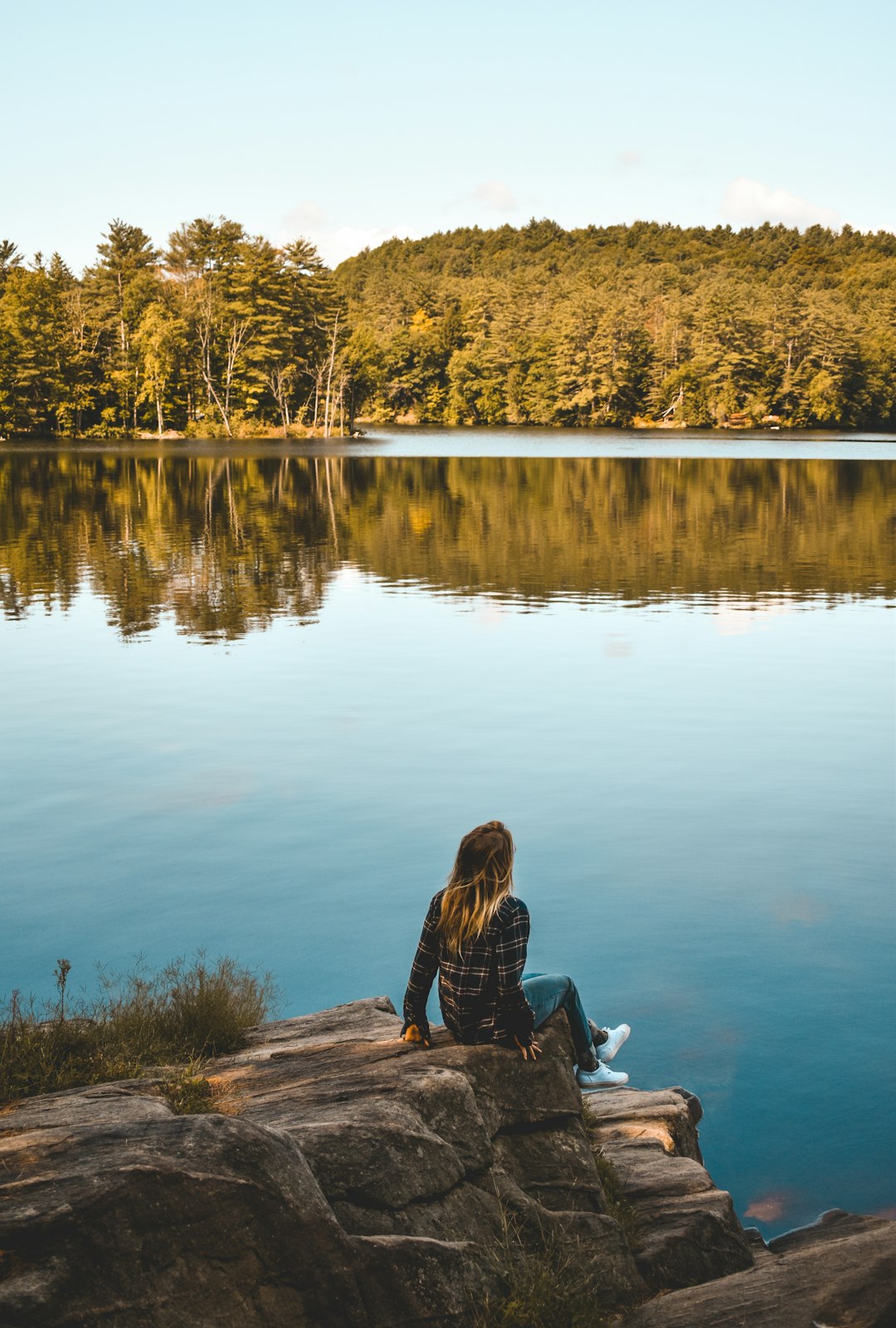 Home a-person-sitting-on-a-rock-near-a-lake-8ynfydtvlp0